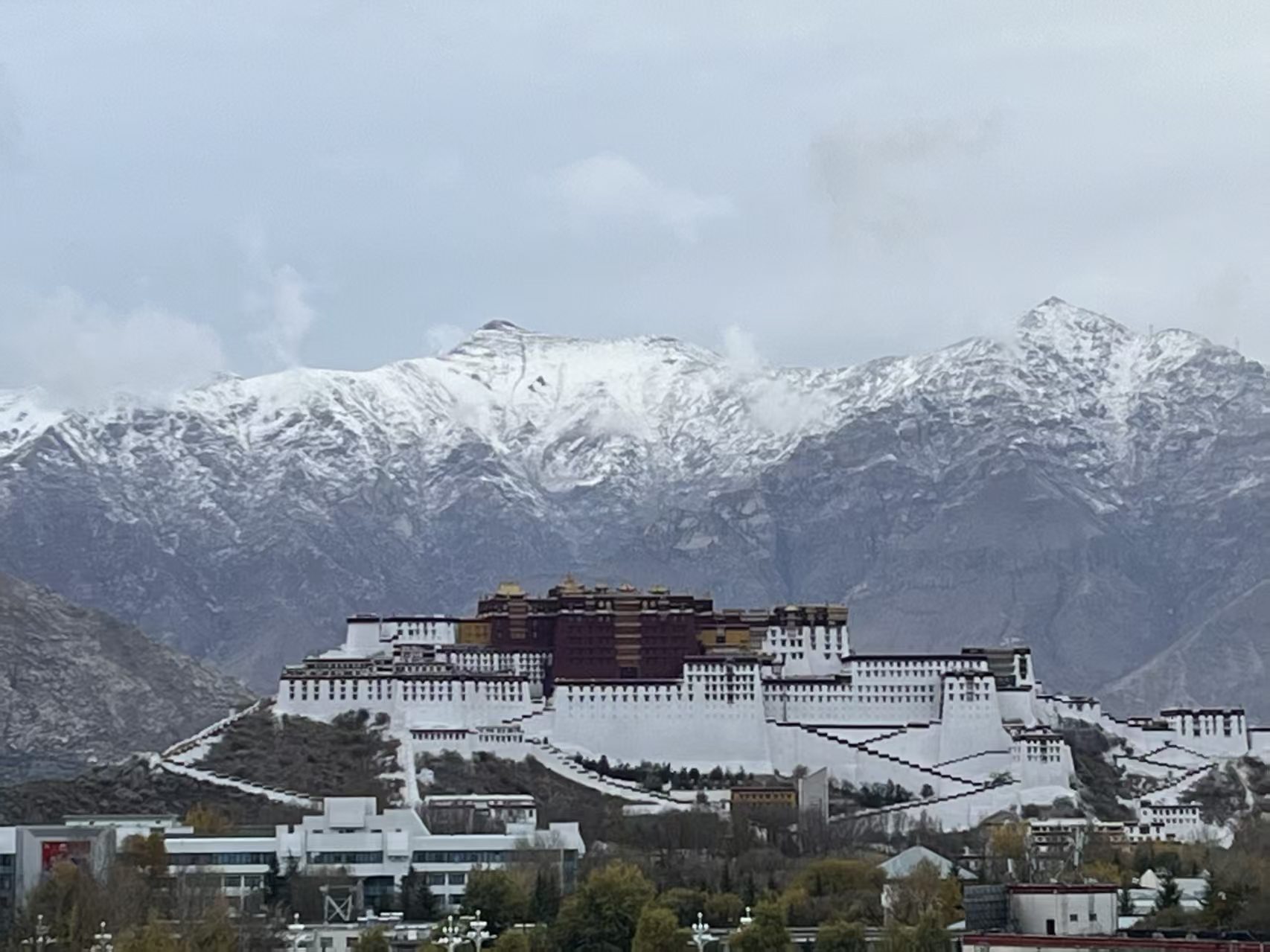 Potala Palace below snow-covered mountains in winter