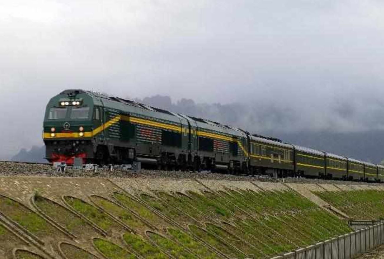 Tibet train running along green plateau hills under cloud