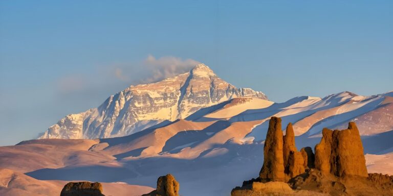 Everest at sunset above eroded earth pillars