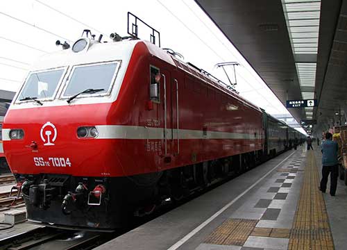 Red train waiting at a Tibet railway platform